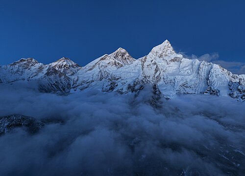 The mountain Mount Everest, peak rising high above dusk clouds